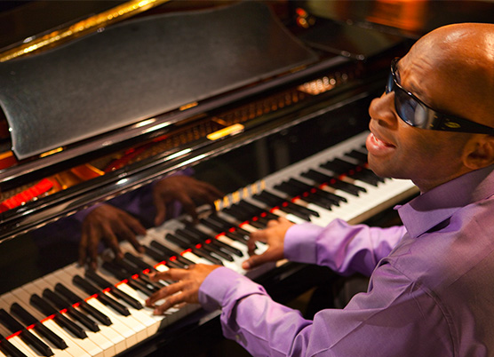 a man wearing sunglasses playing the piano