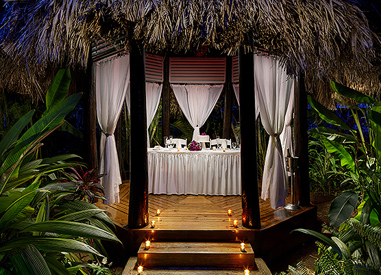 a private dinner in a gazebo secluded with white curtains at night
