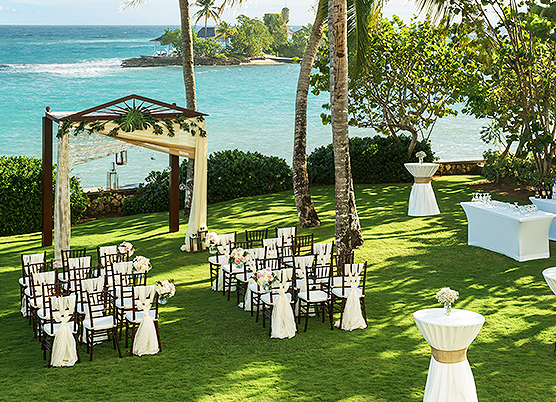 small wedding ceremony set up on a lawn overlooking the ocean