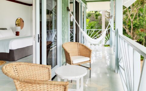 patio chairs and a hammock on a balcony outside a guest bedroom