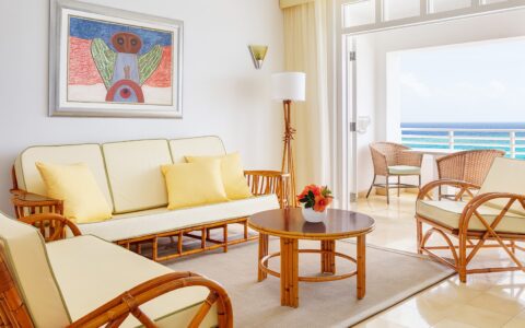 living room with light yellow cushions and a view of the balcony overlooking the ocean